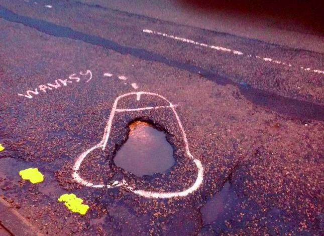 wanksy pothole street art